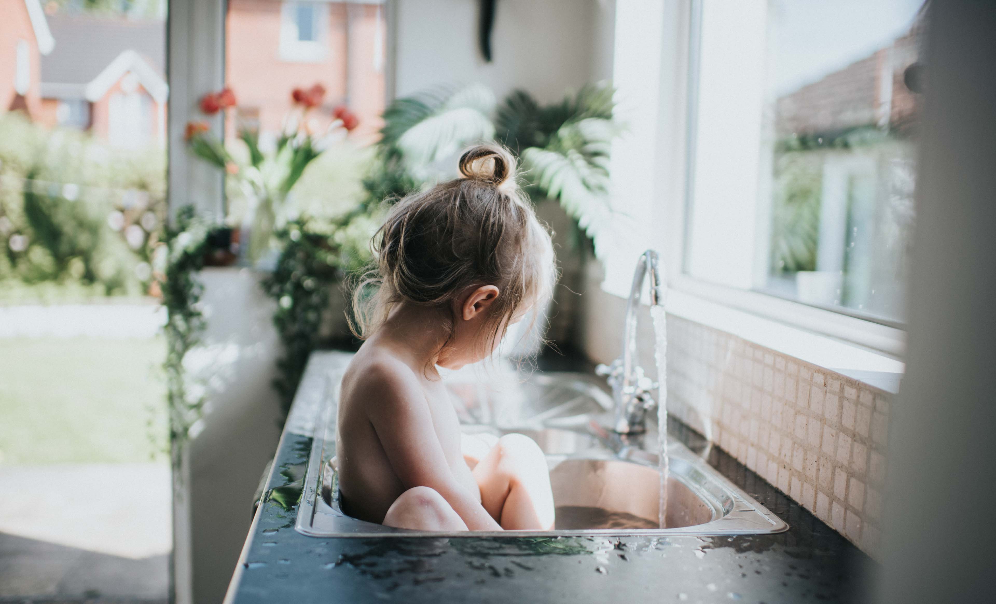 Small girl in a kitchen sink